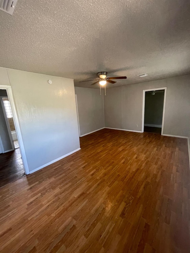 unfurnished room featuring dark wood-type flooring, a textured ceiling, and ceiling fan