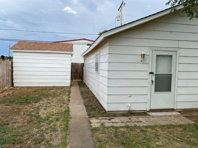 view of side of home with a yard and an outbuilding