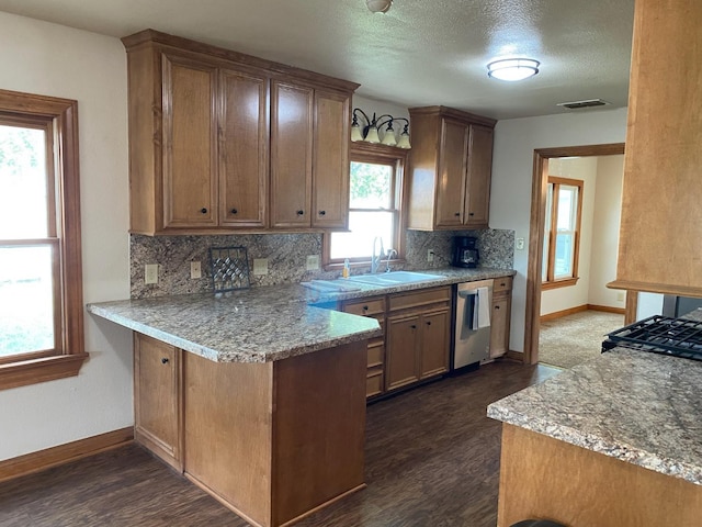 kitchen with sink, tasteful backsplash, dishwasher, kitchen peninsula, and light stone countertops