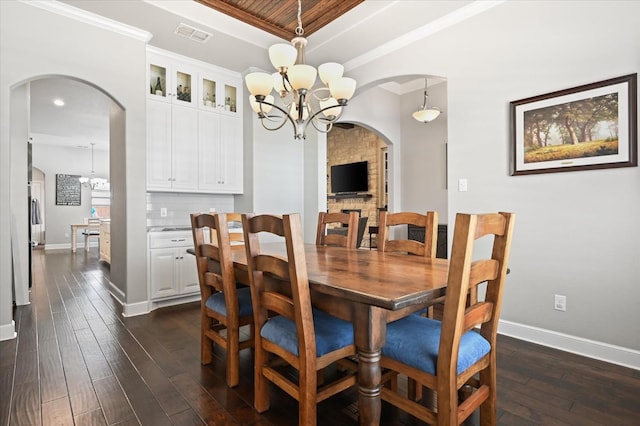 dining space featuring an inviting chandelier, wood ceiling, dark wood-type flooring, and ornamental molding