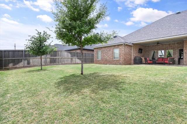 view of yard with outdoor lounge area and ceiling fan