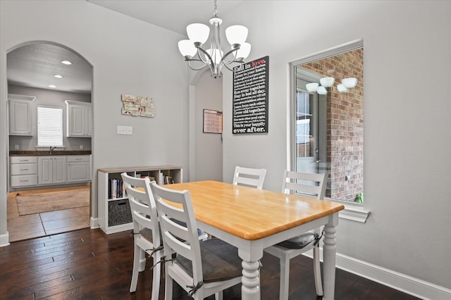 dining room featuring sink, dark hardwood / wood-style floors, and a chandelier