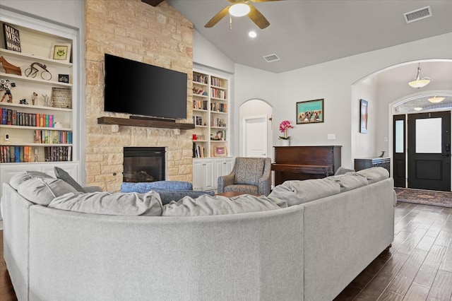 living room with dark hardwood / wood-style floors, a fireplace, vaulted ceiling, and built in features