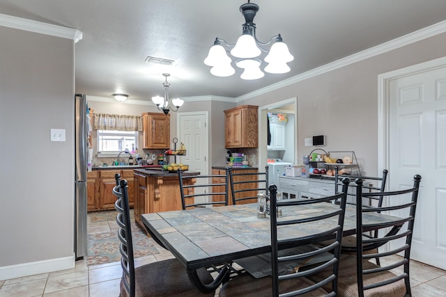 dining room featuring a chandelier, crown molding, baseboards, and light tile patterned flooring