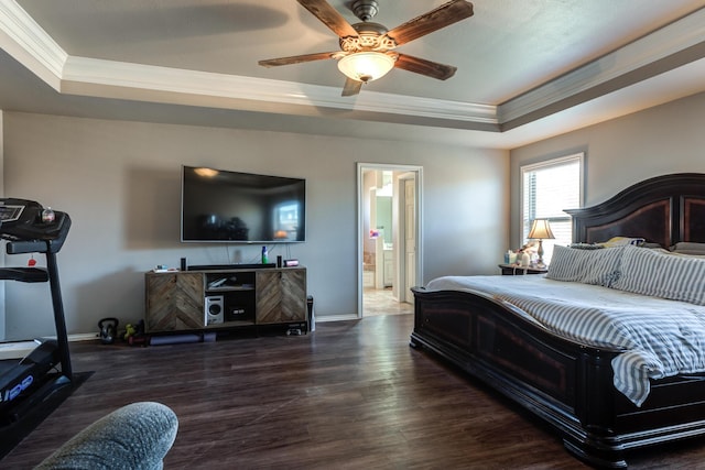 bedroom featuring a raised ceiling, ornamental molding, baseboards, and wood finished floors