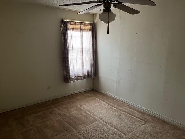 3193 US Highway 385, Littlefield, TX 79339 - carpeted spare room featuring a textured ceiling and a ceiling fan