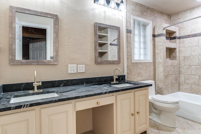 full bathroom with tile patterned floors, vanity, toilet, and tiled shower / bath combo