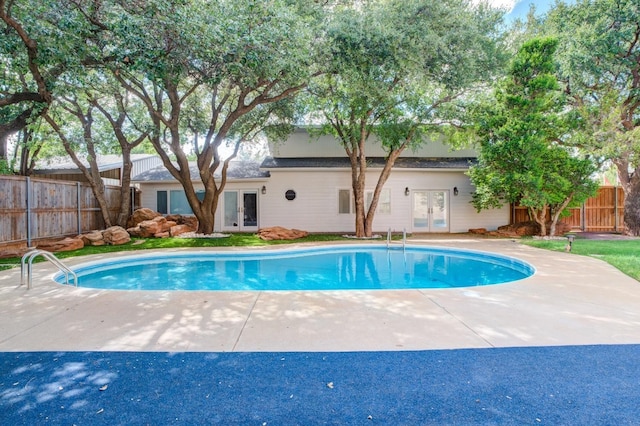 view of swimming pool with french doors and a patio area