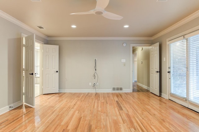 spare room with ornamental molding, a wealth of natural light, and light wood-type flooring