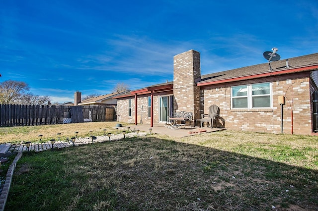 back of house featuring a patio and a lawn