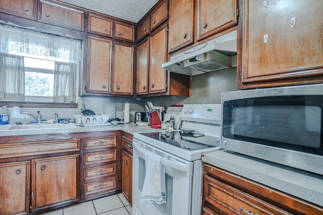 kitchen featuring sink, light tile patterned floors, a textured ceiling, and white range with electric stovetop