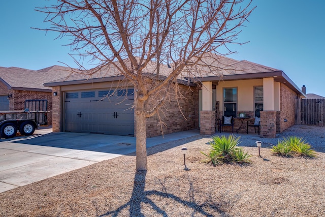 ranch-style house with stucco siding, brick siding, fence, driveway, and an attached garage