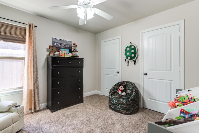 recreation room featuring baseboards, a ceiling fan, and carpet floors