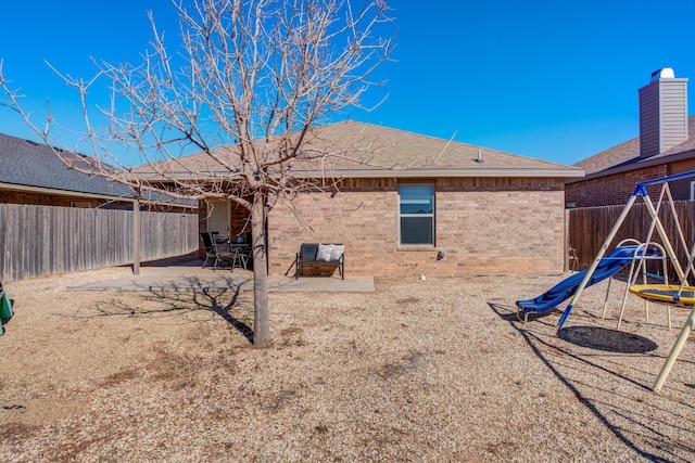 back of house featuring a patio area, brick siding, and a fenced backyard