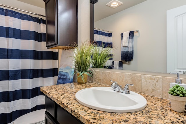 bathroom featuring toilet, curtained shower, and vanity