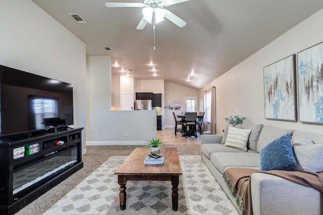 living room featuring visible vents, ceiling fan, vaulted ceiling, and baseboards