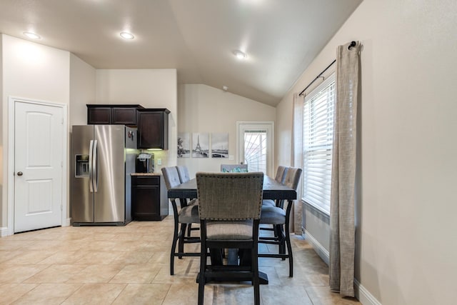 dining room with baseboards and lofted ceiling