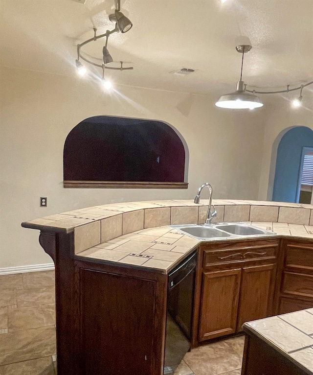 kitchen with pendant lighting, sink, light tile patterned floors, dishwasher, and tile countertops