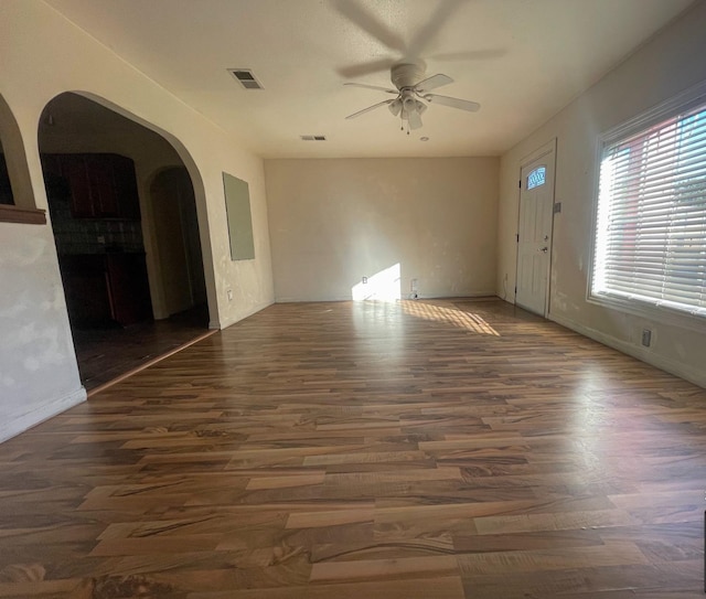 unfurnished living room featuring ceiling fan and dark hardwood / wood-style floors