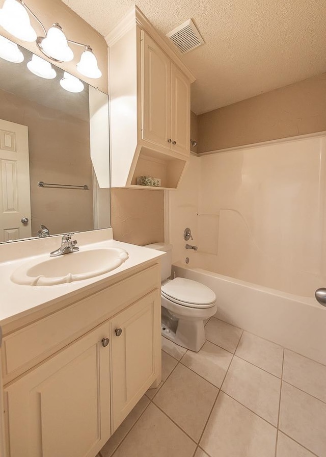 full bathroom featuring shower / washtub combination, vanity, a textured ceiling, tile patterned floors, and toilet