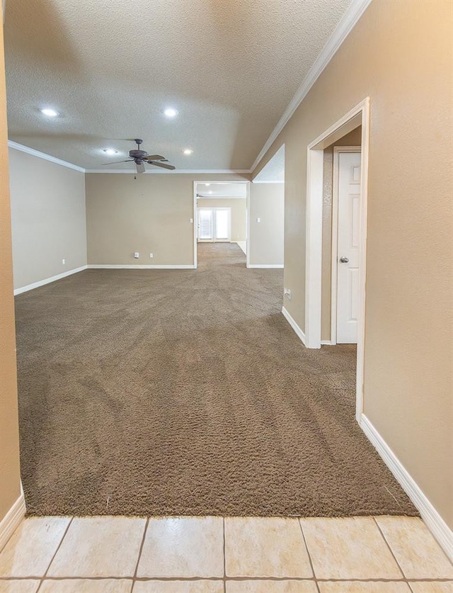 tiled spare room with ceiling fan, ornamental molding, and a textured ceiling