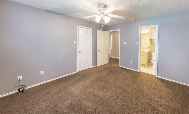 unfurnished bedroom with ensuite bath, ceiling fan, carpet floors, a textured ceiling, and a closet