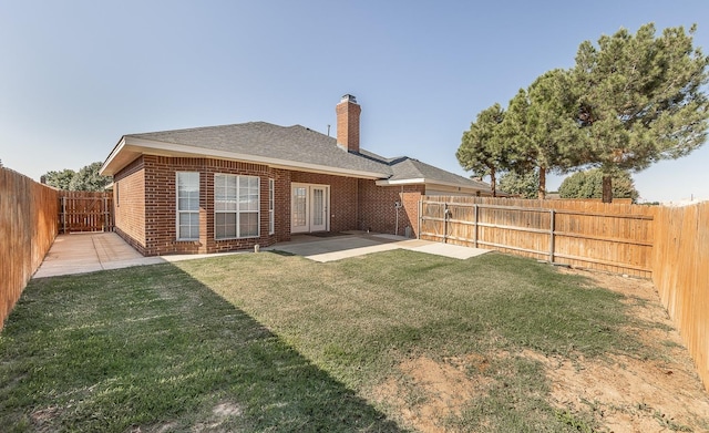 rear view of house featuring a patio and a yard