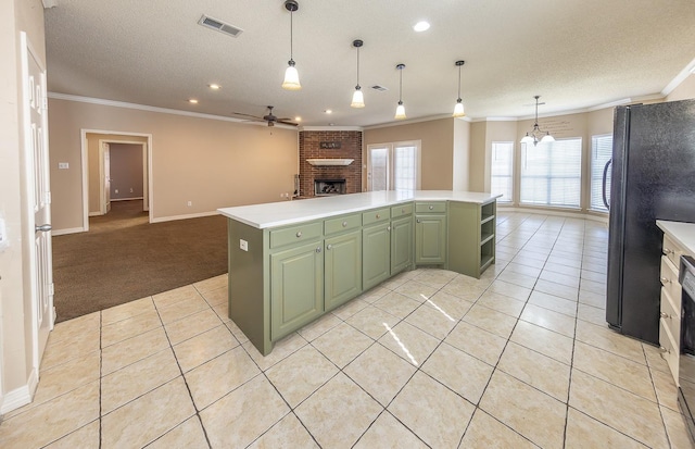 kitchen featuring black fridge, green cabinetry, ornamental molding, and a center island