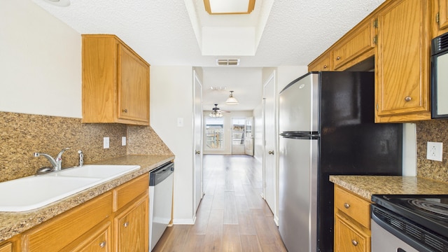 5768 38th St, Lubbock, TX 79407 - kitchen featuring visible vents, appliances with stainless steel finishes, wood finished floors, light countertops, and a sink