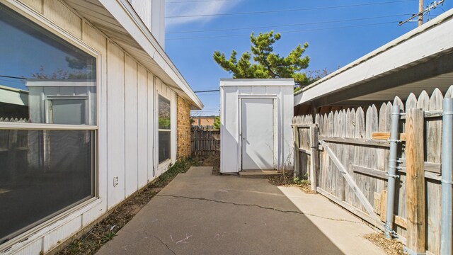 5768 38th St, Lubbock, TX 79407 - view of property exterior with an outbuilding, a patio, a shed, and fence