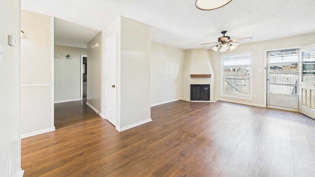 5768 38th St, Lubbock, TX 79407 - unfurnished living room featuring ceiling fan, a fireplace, a textured ceiling, and wood finished floors