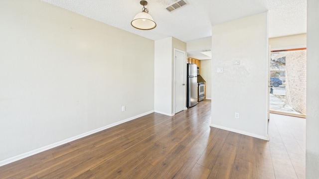 5768 38th St, Lubbock, TX 79407 - unfurnished room with dark wood-style floors, baseboards, visible vents, and a textured ceiling