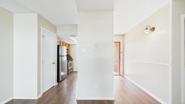 5768 38th St, Lubbock, TX 79407 - hallway featuring a textured ceiling, wood finished floors, and baseboards