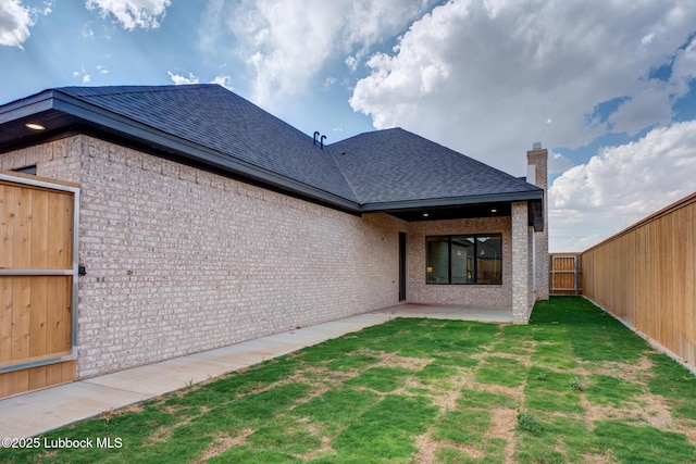 4617 138th Pl, Lubbock, TX 79424 - rear view of property featuring roof with shingles, brick siding, and a patio