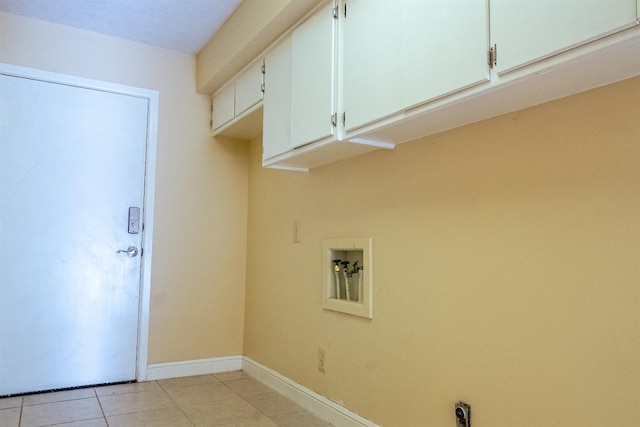 washroom with cabinets, hookup for a washing machine, and light tile patterned floors