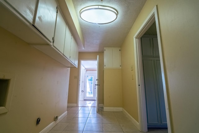 hallway with light tile patterned flooring and a textured ceiling