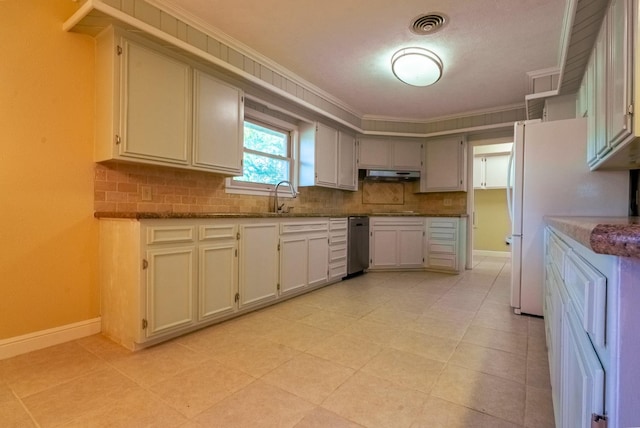 kitchen featuring sink, crown molding, dark stone countertops, white refrigerator, and decorative backsplash