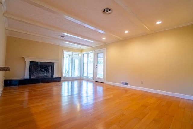 unfurnished living room with beamed ceiling, hardwood / wood-style floors, and a fireplace