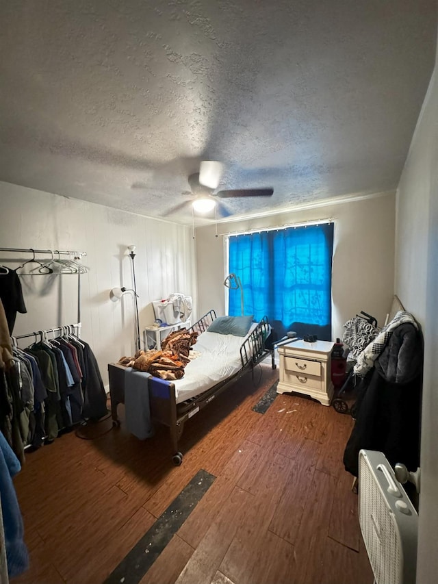 bedroom featuring hardwood / wood-style flooring, a textured ceiling, and ceiling fan