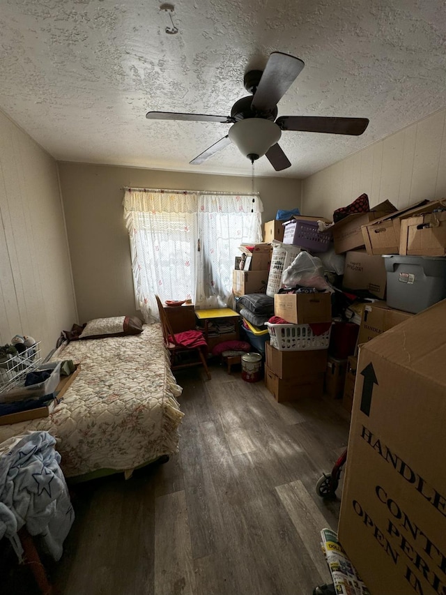 bedroom featuring dark hardwood / wood-style flooring, a textured ceiling, and ceiling fan