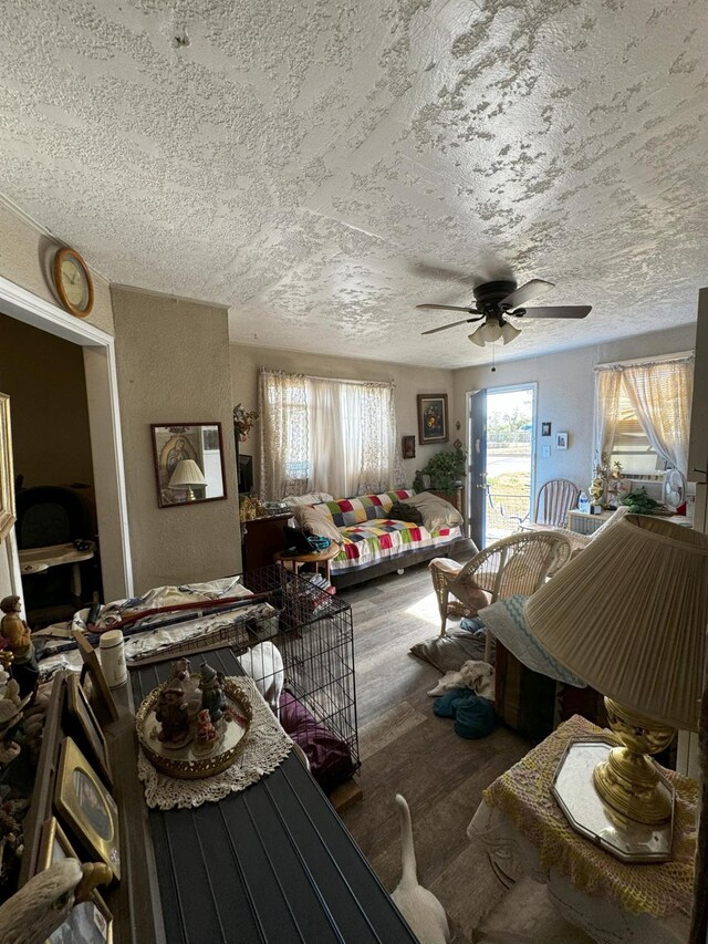 miscellaneous room featuring wood-type flooring, a textured ceiling, and ceiling fan