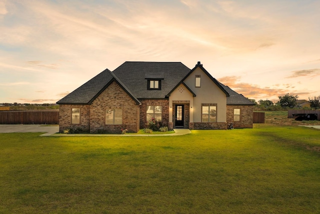 french country home featuring a yard