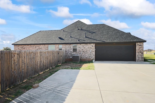 view of front of home featuring cooling unit and a garage