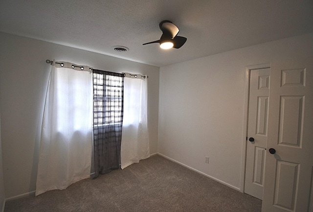 carpeted spare room featuring ceiling fan