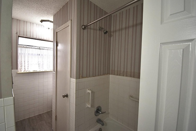 bathroom with hardwood / wood-style flooring, tile walls, a textured ceiling, and shower / bathing tub combination