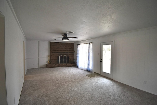 unfurnished living room featuring crown molding, a fireplace, a textured ceiling, and carpet