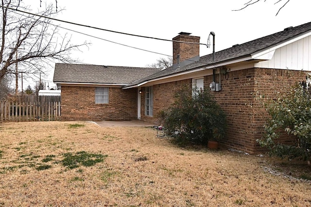 rear view of house featuring a patio area and a lawn