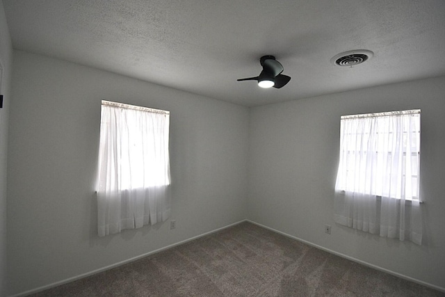 carpeted empty room with ceiling fan and a textured ceiling