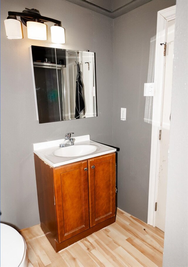 bathroom with vanity, hardwood / wood-style flooring, and toilet