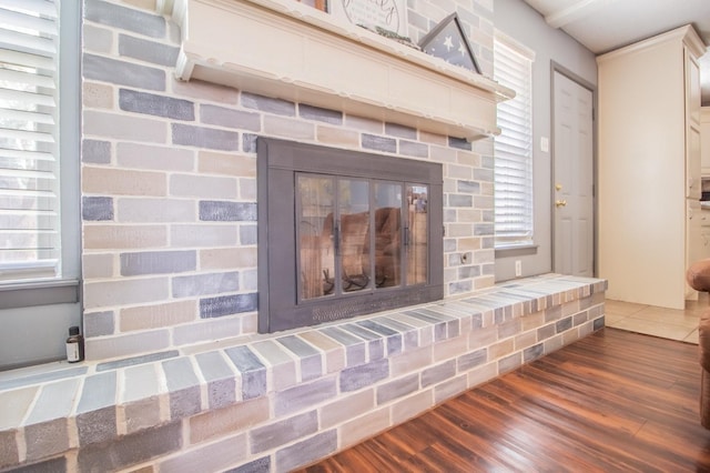 details with hardwood / wood-style flooring and a brick fireplace